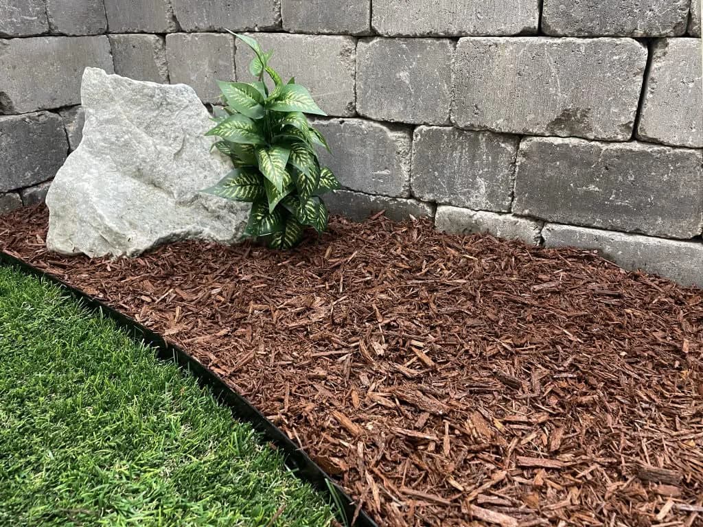 Brown mulch installed along a retaining wall