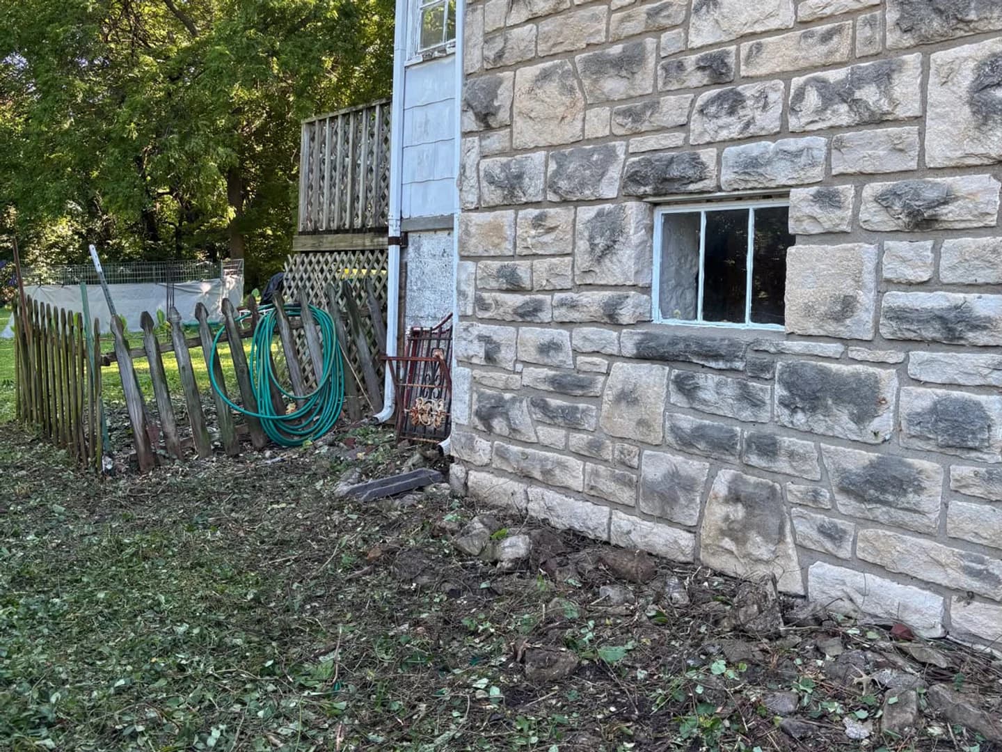 Stone foundation visible after overgrowth was cut back