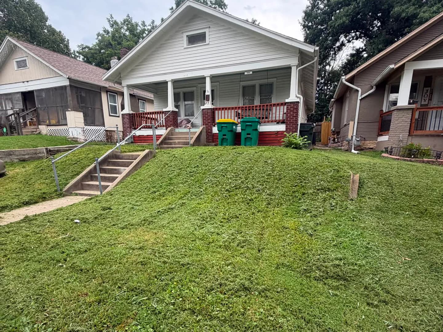 The same front lawn evenly cut after mowing